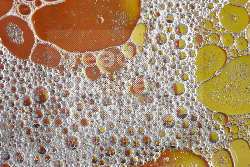 لقطات مقربة لفقاعات الصابون وقطرات الماء على خلفية باللون البرتقالي والأصفر