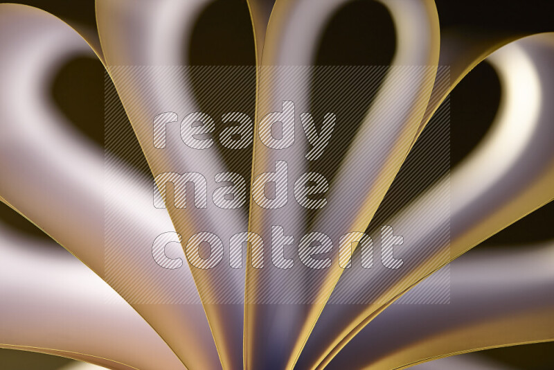 An abstract art piece displaying smooth curves in white and yellow gradients created by colored light