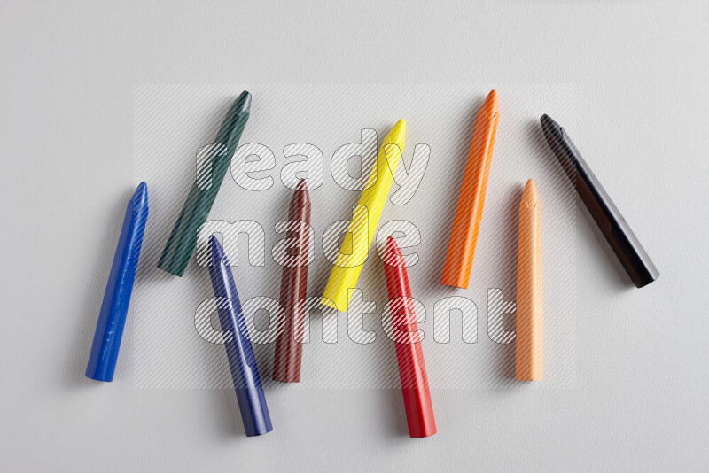 An arrangement of wax crayons in different colors on grey background