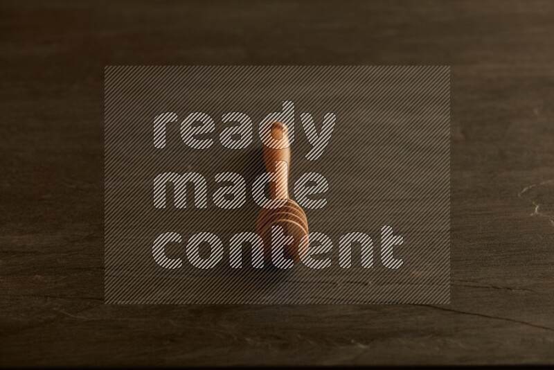 Wooden honey dipper on black slate background