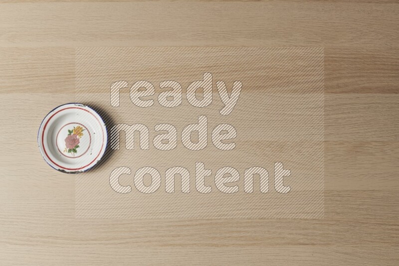 صحن معدني عتيق على خلفية خشبية فاتحة