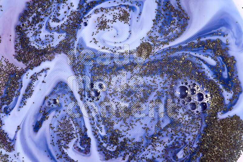 A close-up of sparkling gold glitter scattered on swirling blue and red background