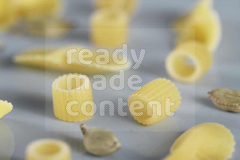 معكرونة مع مكونات متنوعة من الطماطم والثوم والبصل والفلفل الأحمر والفلفل الأسود والفلفل الأبيض وأوراق الغار وإكليل الجبل والهيل و مشروم على خلفية زرقاء فاتحة