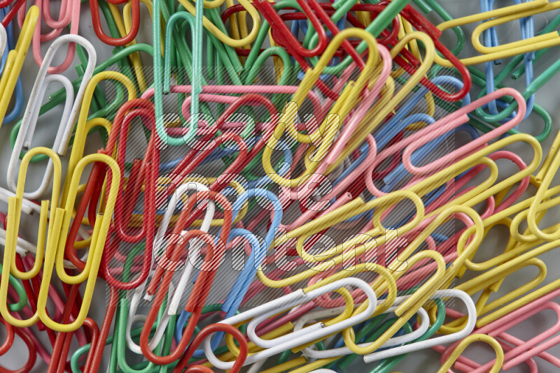 Multicolored paper clips isolated on a grey background