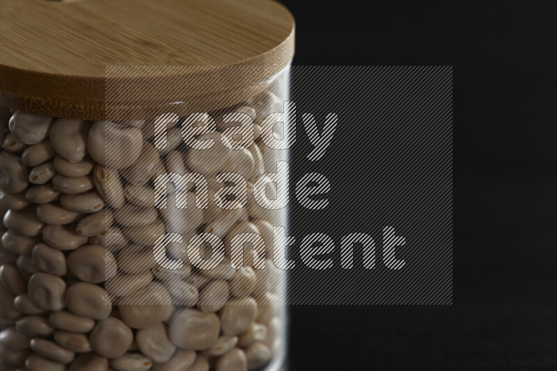 Lupin Beans in a glass jar on black background