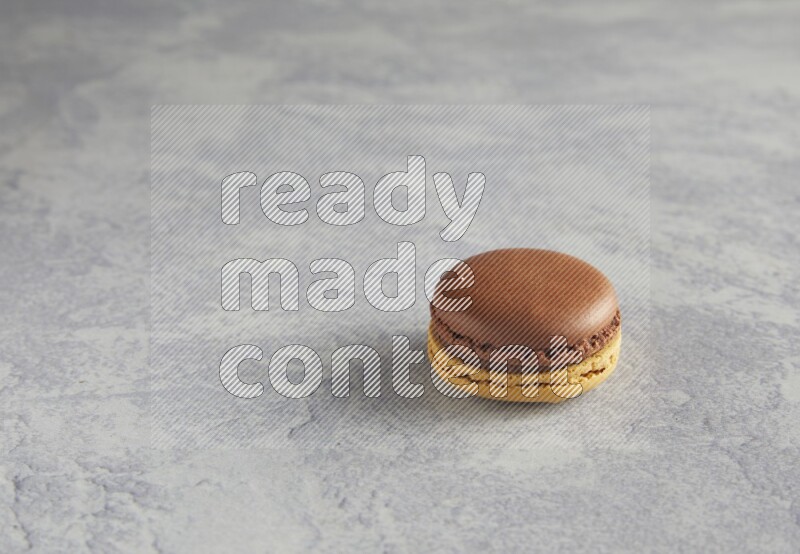 45º Shot of Yellow and Brown Chai Latte macaron on white  marble background