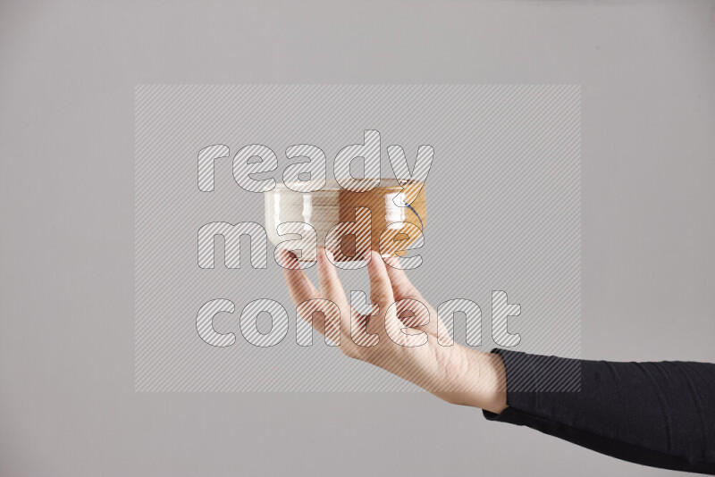 A woman in black abaya holding different pottery essentials in different positions