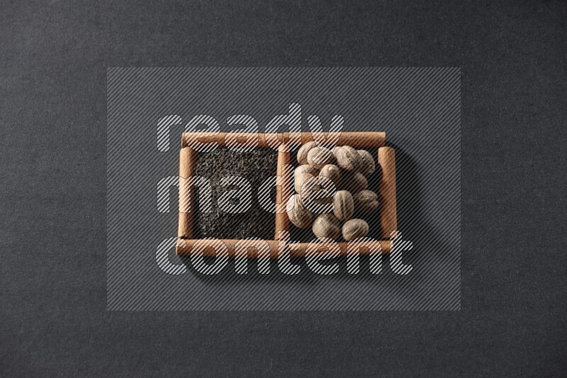 2 squares of cinnamon sticks full of tea and nutmeg on black flooring