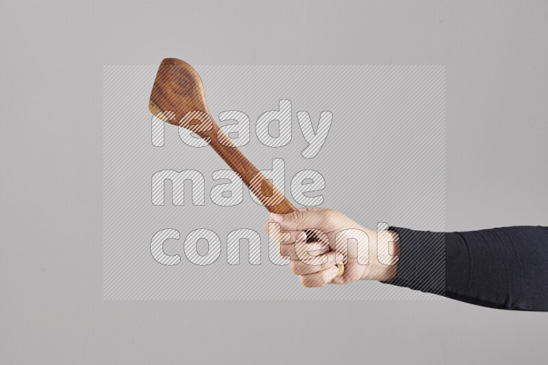 A woman in black abaya holding different wooden essentials in different positions