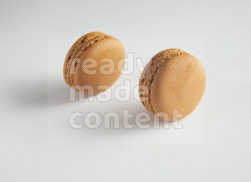 45º Shot of two Brown Maple Taffy macarons on white background
