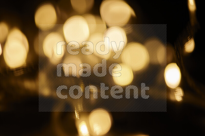 Light bulbs glowing against backdrop of golden bokeh