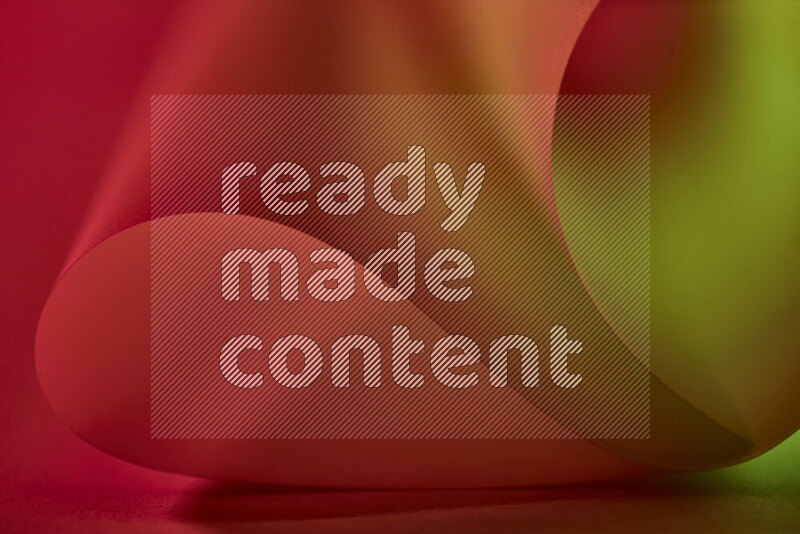 An abstract art piece displaying smooth curves in green and red gradients created by colored light