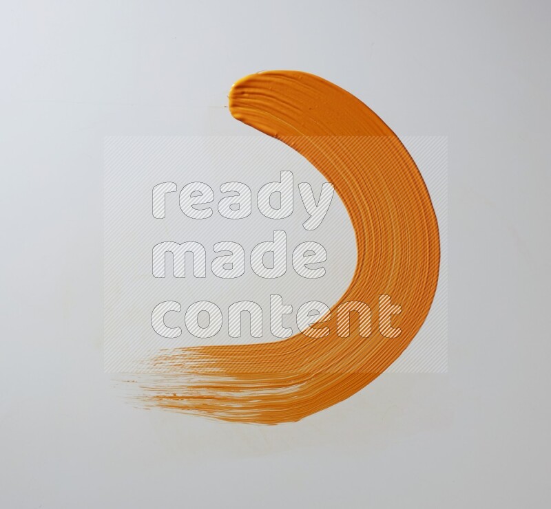 An orange half circular painting brush stroke on white background