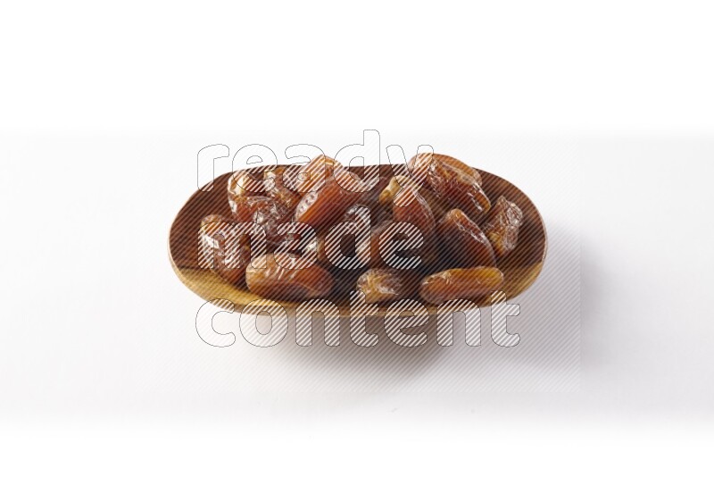 Dates in a wooden plate on white background