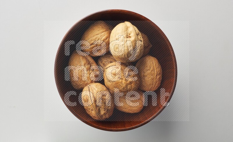 Top-view shot of walnut in a container on white background