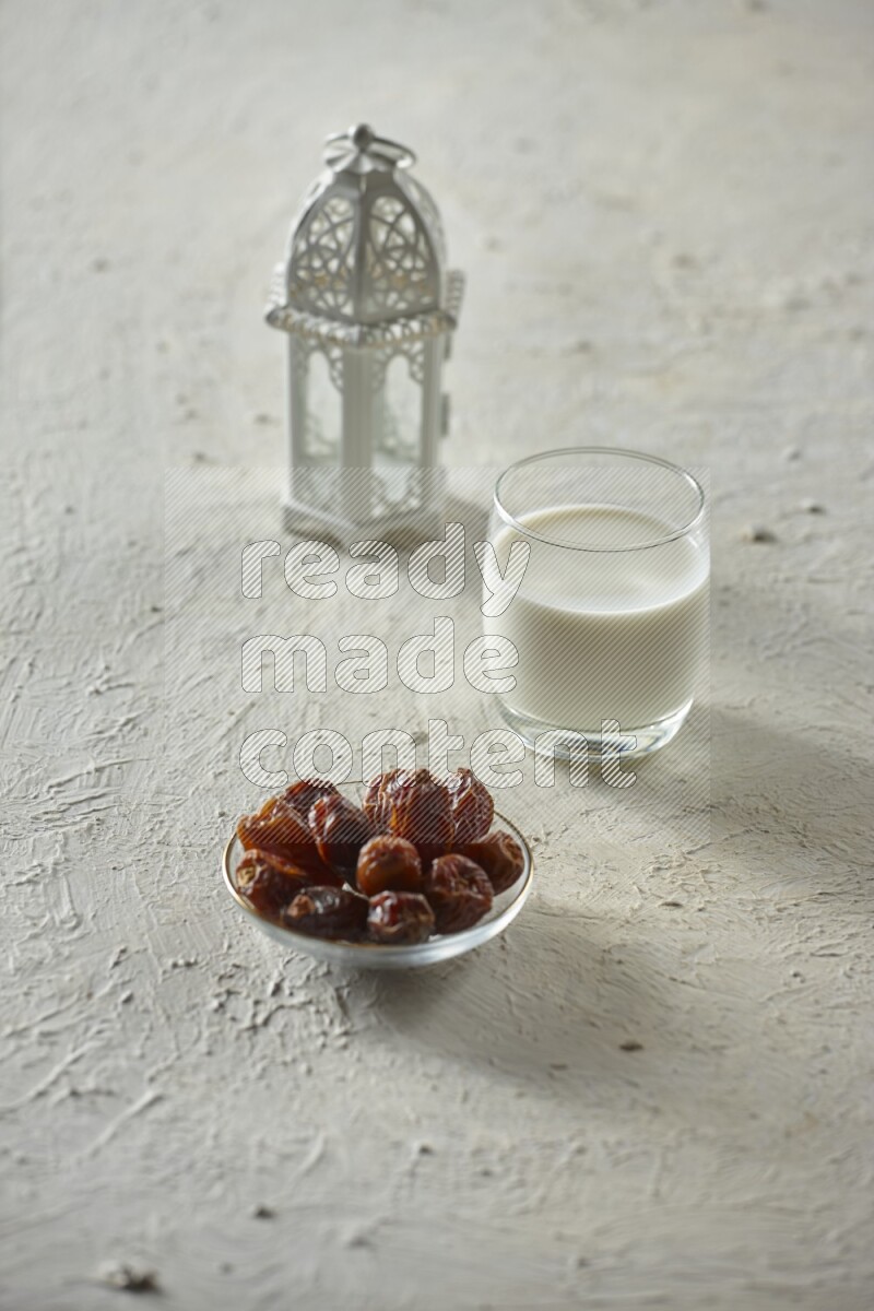 A white lantern with different drinks, dates, nuts, prayer beads and quran on white background