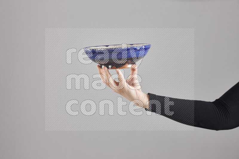 A woman in black abaya holding different pottery essentials in different positions