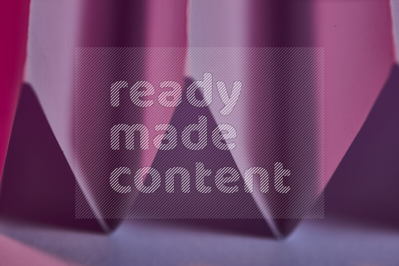 A close-up abstract image showing sharp geometric paper folds in purple gradients
