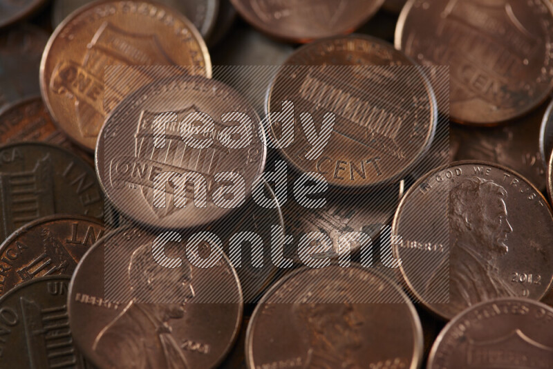 A close-up of scattered United States one cent coins on grey background