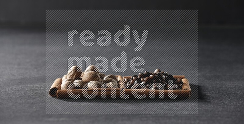 2 squares of cinnamon sticks full of coffee beans and nutmeg on black flooring