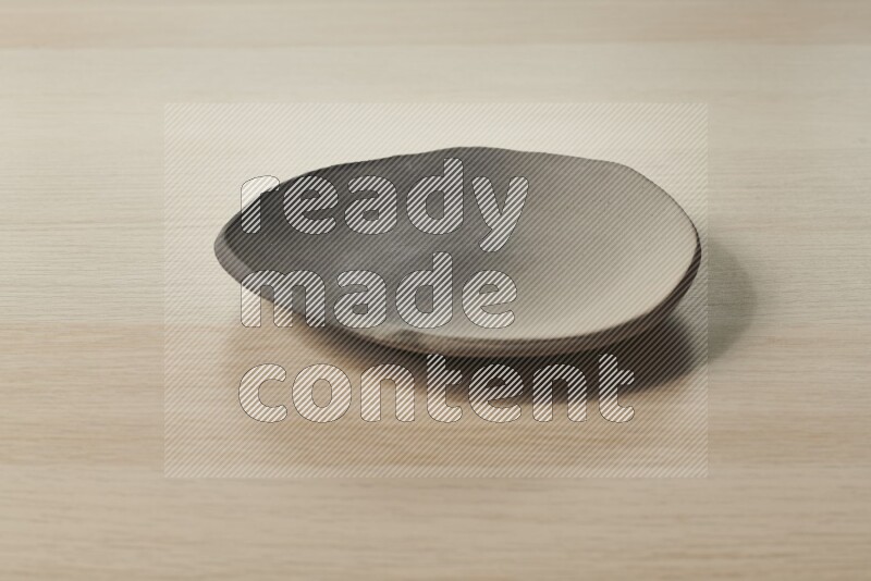 A multicolored pottery plate on light wooden background