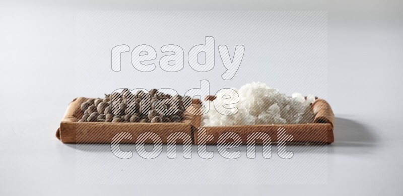 2 squares of cinnamon sticks full of white salt and allspice on white flooring