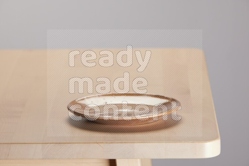 multi-colored pottery Plate on a wooden table edge