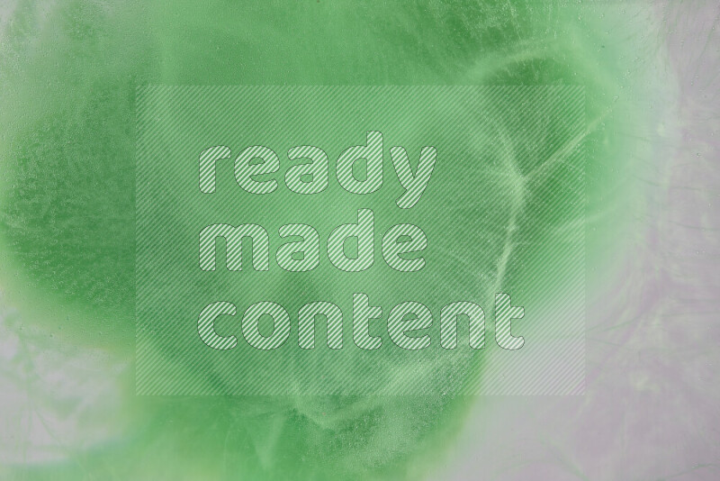 The image captures a dramatic splatter of green paint over a white backdrop