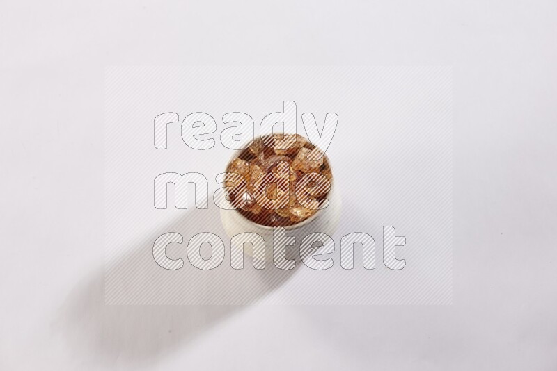 A beige pottery bowl full of gum arabic on white flooring
