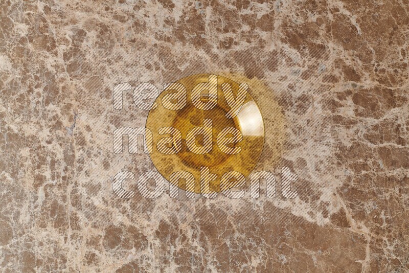 A circular glass plate on beige marble background