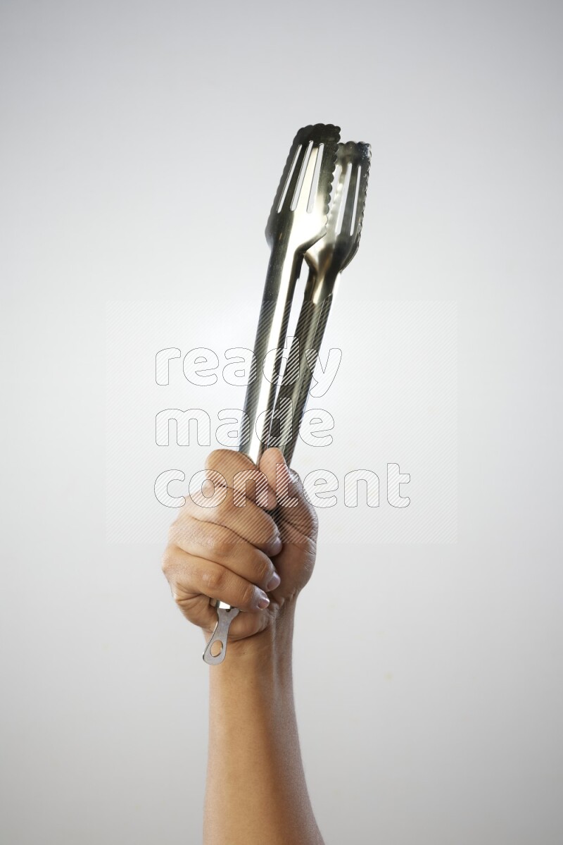 Male Hand Holding Tongs on white background