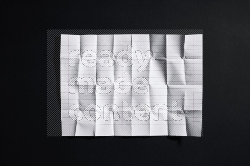 Folded notebook sheet on black background