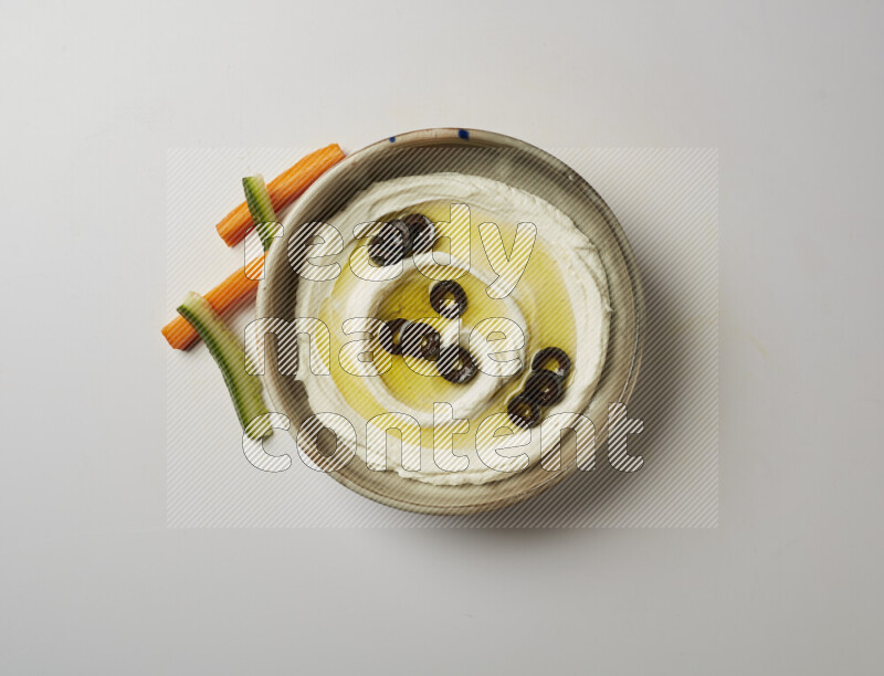 Lebnah garnished with sliced olives in a grey pottery plate on a white background