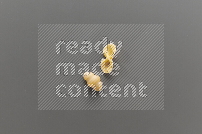 Snails pasta with other types of pasta on grey background