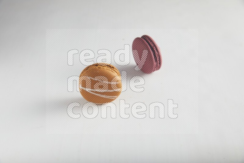 45º Shot of of two assorted Brown Irish Cream, and Red Cherry macarons on white background