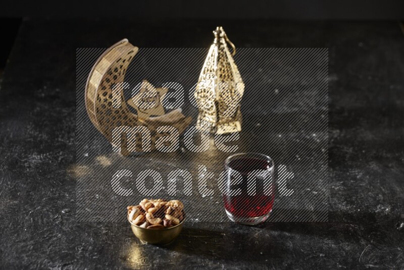 Nuts in a metal bowl with Hibiscus beside golden lanterns in a dark setup