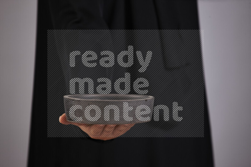 امرأة ترتدي عباءة سوداء تحمل أدوات فخارية مختلفة في أوضاع متعددة