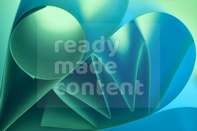 An artistic display of paper folds creating a harmonious blend of geometric shapes, highlighted by soft lighting in green and blue tones
