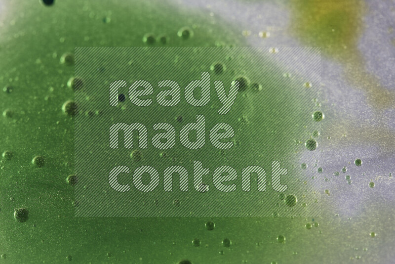 لقطات مقربة لقطرات ألوان مائية صفراء وزرقاء وخضراء على سطح الزيت على خلفية بيضاء