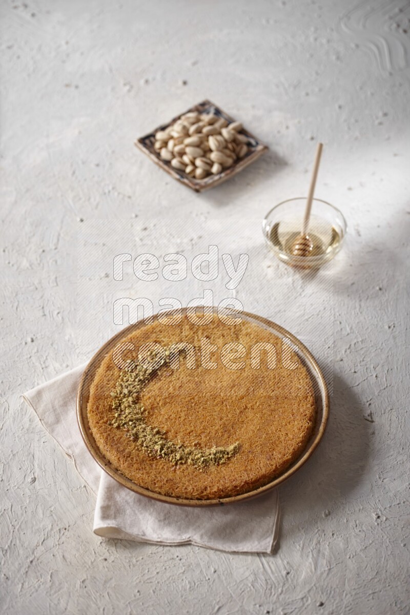 Konafa with nuts and honey in a light setup