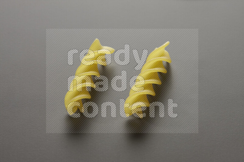 Fusilli pasta on grey background
