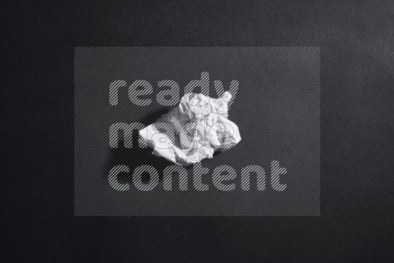 Crumpled notebook sheet on black background