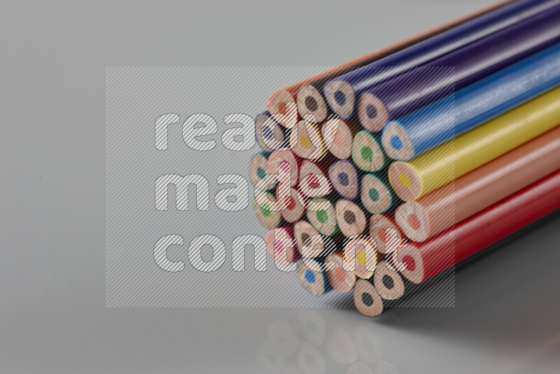 An array of colored pencils on grey background