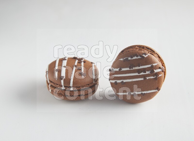 45º Shot of two Brown white Chocolate Caramel macarons on white background
