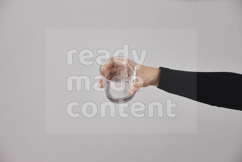 امرأة ترتدي عباءة سوداء تحمل أدوات زجاجية مختلفة في أوضاع متعددة