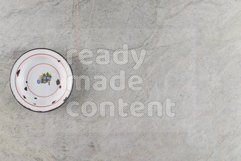 صحن معدني عتيق على خلفية من الرخام الرمادي