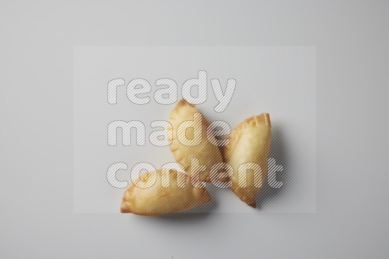 Three fried sambosa from a top angle on a white background