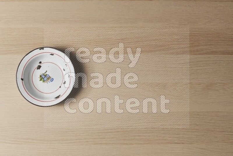 A vintage metal plate on light wooden background