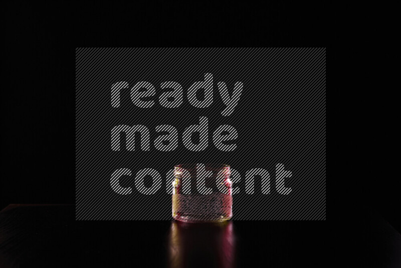 Glassware with rim light in red and yellow against black background