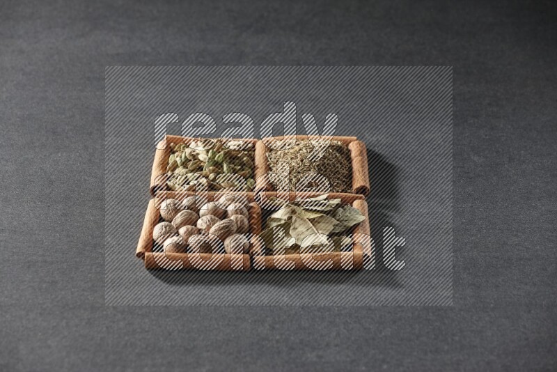 4 squares of cinnamon sticks full of cumin, cardamom, bay laurel leaves and nutmegs on black flooring